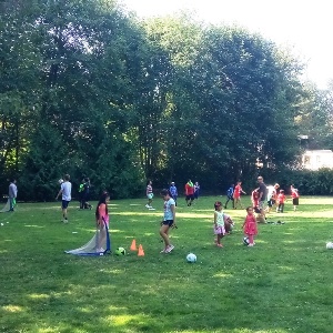 Children and adults playing ball in a park